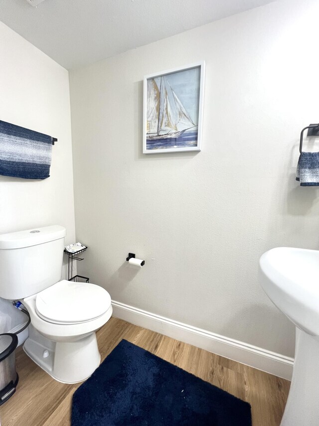 bathroom with toilet and hardwood / wood-style flooring