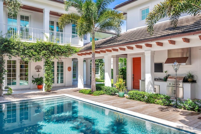 view of pool featuring french doors, area for grilling, and a patio