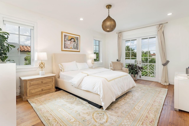 bedroom with multiple windows and light hardwood / wood-style flooring