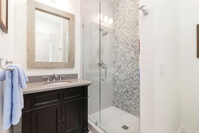 bathroom featuring a shower with door and vanity