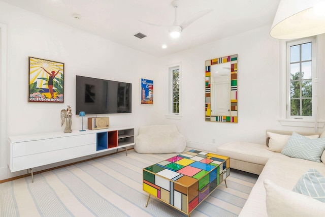 carpeted living room with ceiling fan