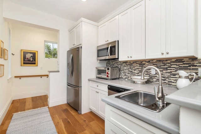 kitchen featuring light hardwood / wood-style flooring, stainless steel appliances, sink, and white cabinetry