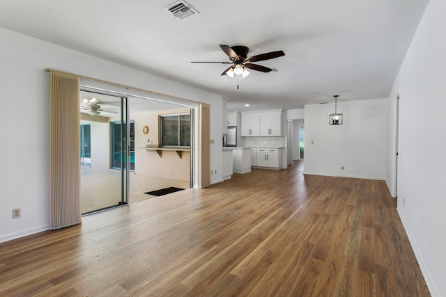 unfurnished living room with ceiling fan and wood-type flooring