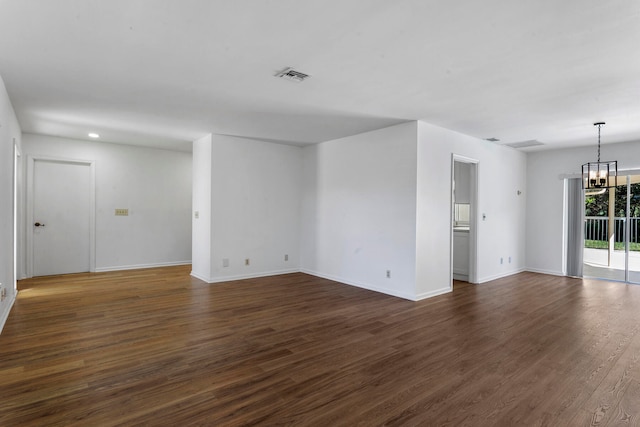 unfurnished room with dark wood-type flooring and a notable chandelier