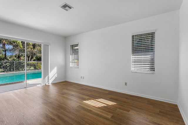 unfurnished room with dark wood-type flooring