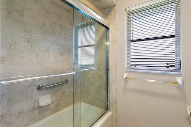 bathroom with shower / bath combination with glass door and plenty of natural light