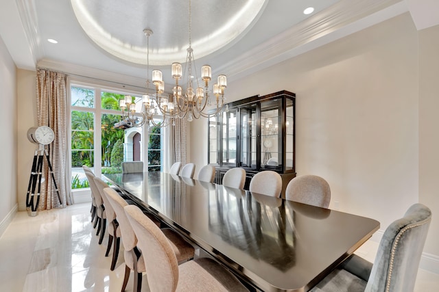 dining space featuring a raised ceiling, ornamental molding, and a chandelier