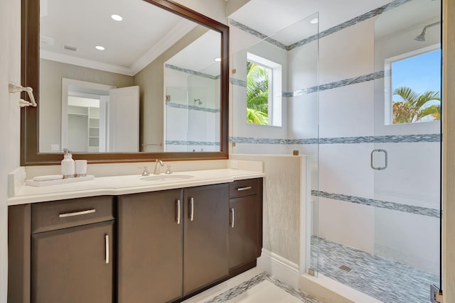 bathroom featuring walk in shower, crown molding, and vanity