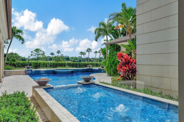 view of swimming pool featuring an in ground hot tub and a patio