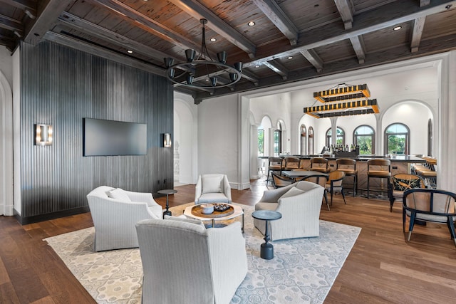 living room featuring wood ceiling, wood-type flooring, an inviting chandelier, and beam ceiling