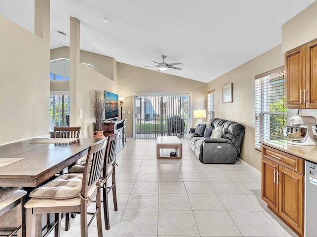 interior space with lofted ceiling, ceiling fan, and light tile patterned flooring