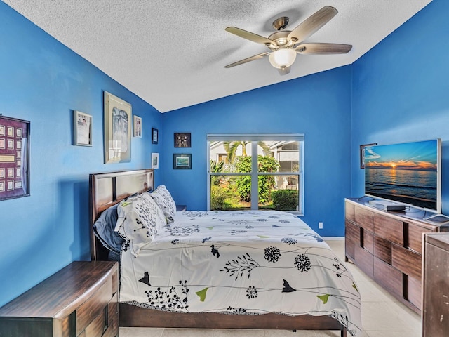 tiled bedroom with vaulted ceiling, ceiling fan, and a textured ceiling