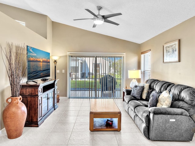 living room featuring a textured ceiling, light tile patterned floors, lofted ceiling, and ceiling fan