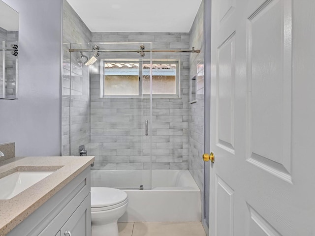 full bathroom featuring bath / shower combo with glass door, vanity, toilet, and tile patterned floors