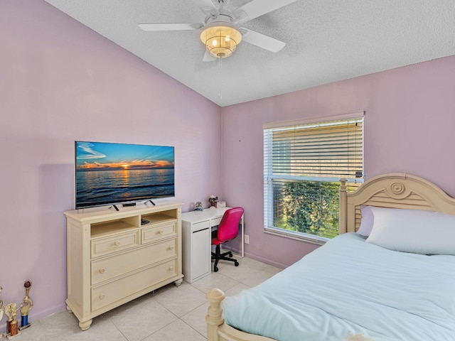 tiled bedroom with vaulted ceiling, ceiling fan, and a textured ceiling