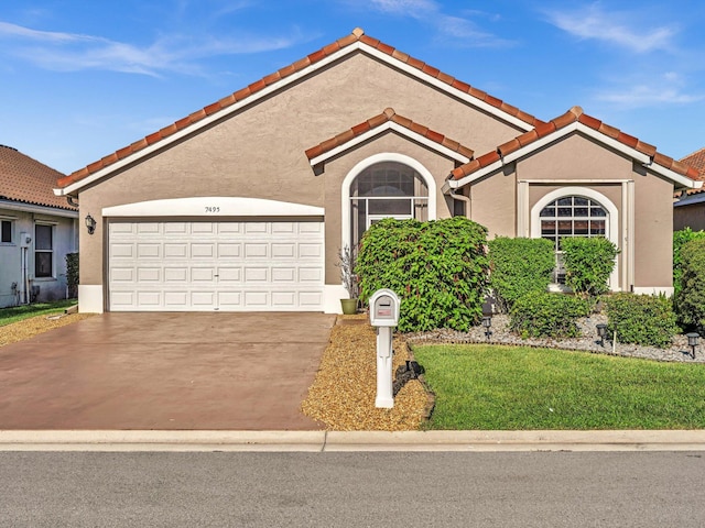 mediterranean / spanish-style home with a garage and a front yard