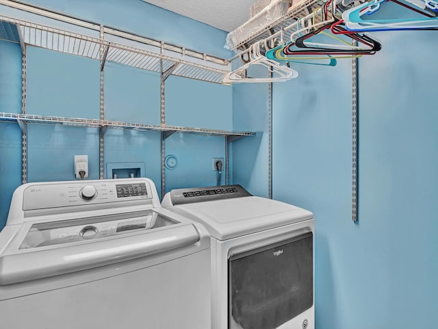 washroom featuring washing machine and clothes dryer and a textured ceiling