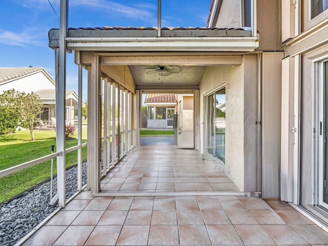 exterior space featuring ceiling fan and a lawn