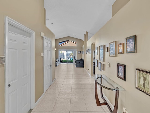 hallway featuring light tile patterned flooring and vaulted ceiling