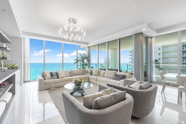 tiled living room featuring a water view, expansive windows, and a chandelier