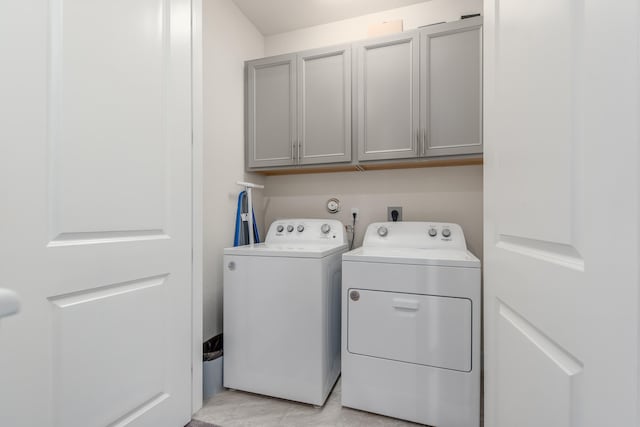 washroom with separate washer and dryer and cabinets