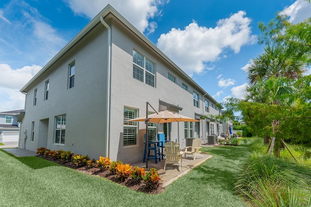 rear view of house with a yard, central air condition unit, and a patio area