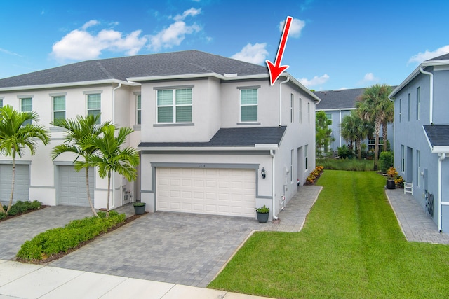 view of front of property featuring a front yard and a garage