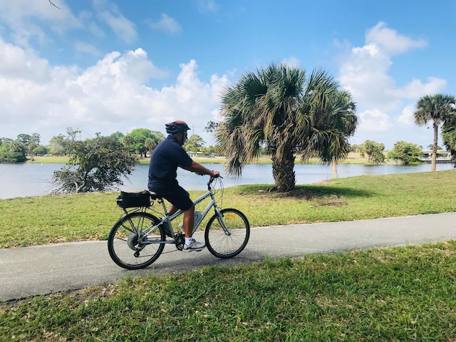 surrounding community with a lawn and a water view