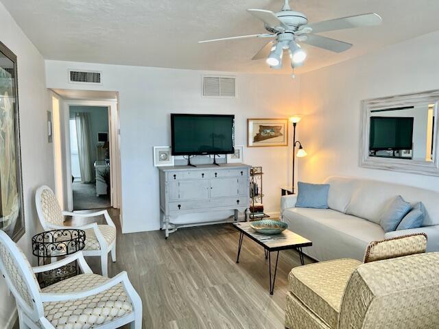 living room featuring hardwood / wood-style floors and ceiling fan