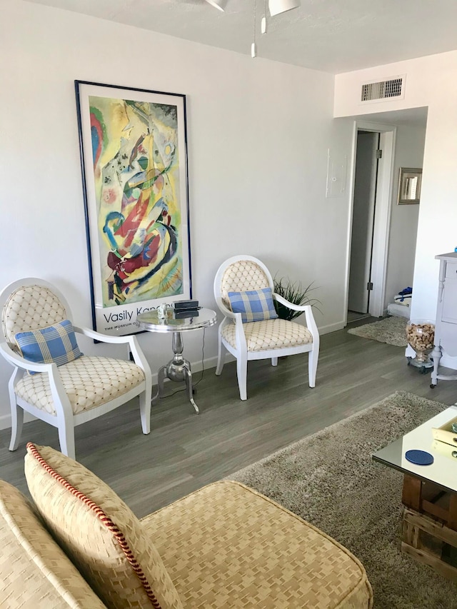 sitting room featuring wood-type flooring and ceiling fan