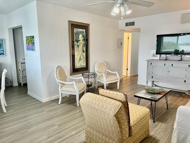 living room featuring ceiling fan and light hardwood / wood-style floors