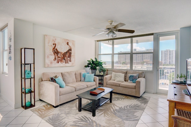 tiled living room with ceiling fan, expansive windows, and a textured ceiling