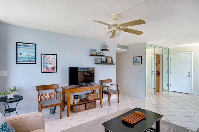 tiled living room featuring ceiling fan and a textured ceiling