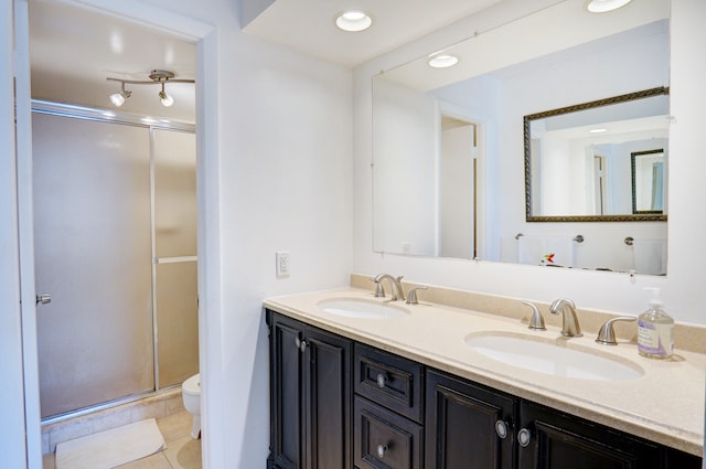 bathroom featuring vanity, a shower with shower door, toilet, and tile patterned floors