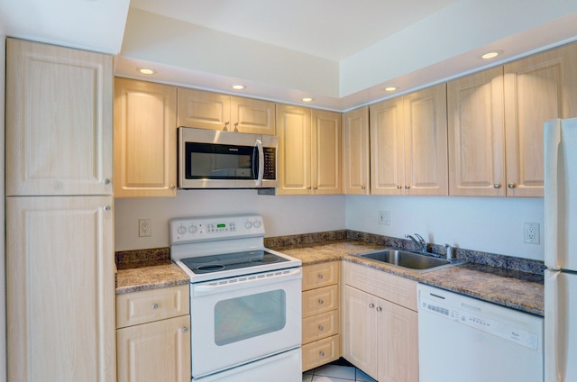 kitchen featuring light tile patterned floors, light brown cabinets, sink, and white appliances