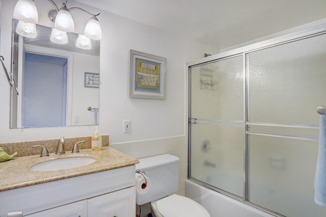 full bathroom featuring shower / bath combination with glass door, vanity, and toilet