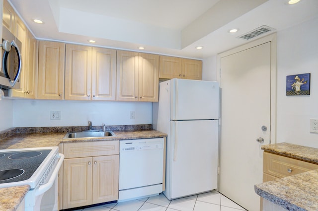 kitchen with light brown cabinetry, white appliances, sink, and light tile patterned floors