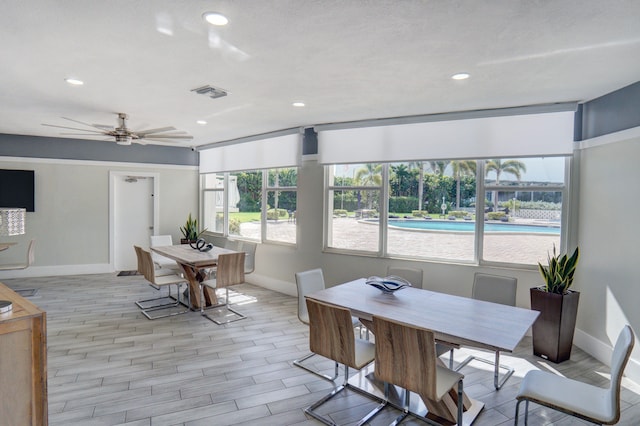 dining space with ceiling fan and light hardwood / wood-style flooring