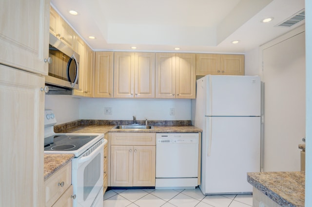 kitchen featuring sink, white appliances, a raised ceiling, light tile patterned floors, and light brown cabinetry