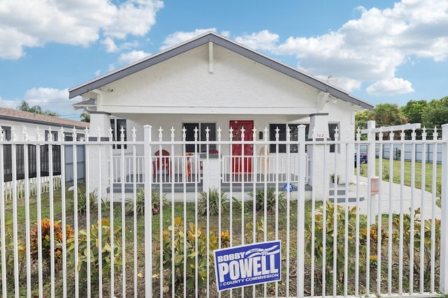 bungalow-style home with fence and stucco siding