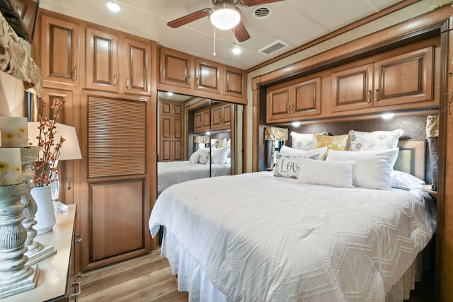 bedroom with light hardwood / wood-style flooring, ceiling fan, and a closet