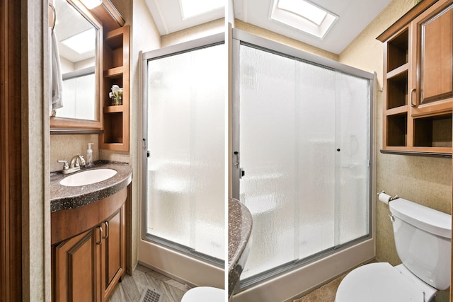 bathroom with vanity, toilet, and walk in shower