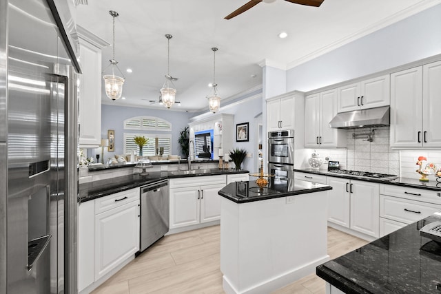 kitchen with a center island, appliances with stainless steel finishes, white cabinetry, kitchen peninsula, and ceiling fan