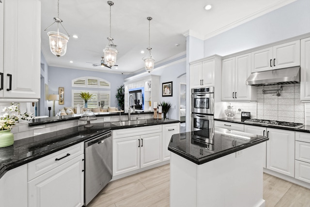 kitchen with appliances with stainless steel finishes, a kitchen island, and white cabinetry