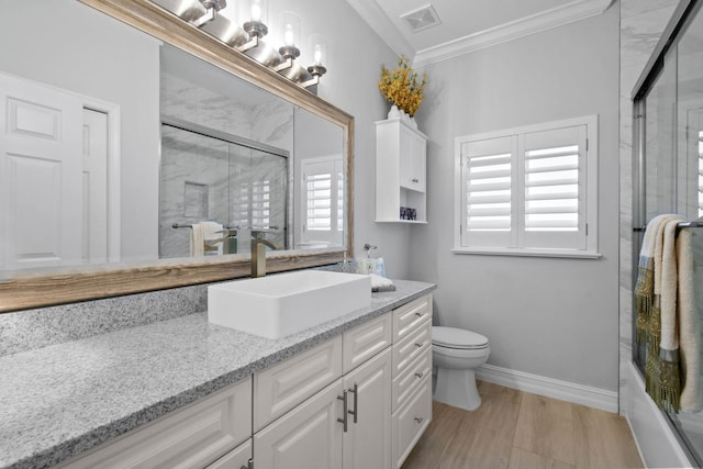 full bathroom with enclosed tub / shower combo, hardwood / wood-style flooring, toilet, vanity, and ornamental molding