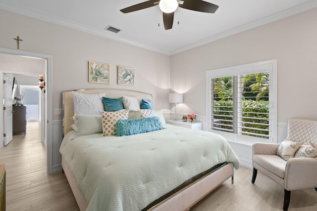 bedroom with ceiling fan, ornamental molding, and light wood-type flooring