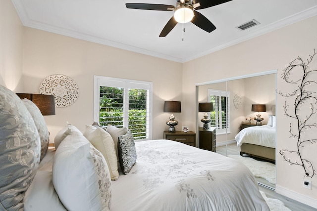 bedroom featuring crown molding, ceiling fan, a closet, and light wood-type flooring