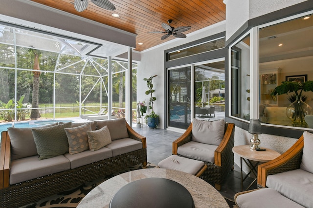 view of patio / terrace with an outdoor living space, ceiling fan, and a lanai