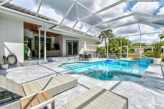 view of swimming pool with glass enclosure, a patio area, area for grilling, and ceiling fan