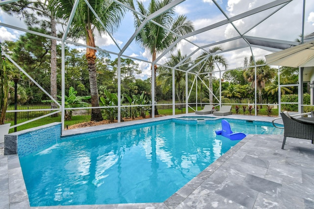 view of swimming pool featuring a lanai and a patio area